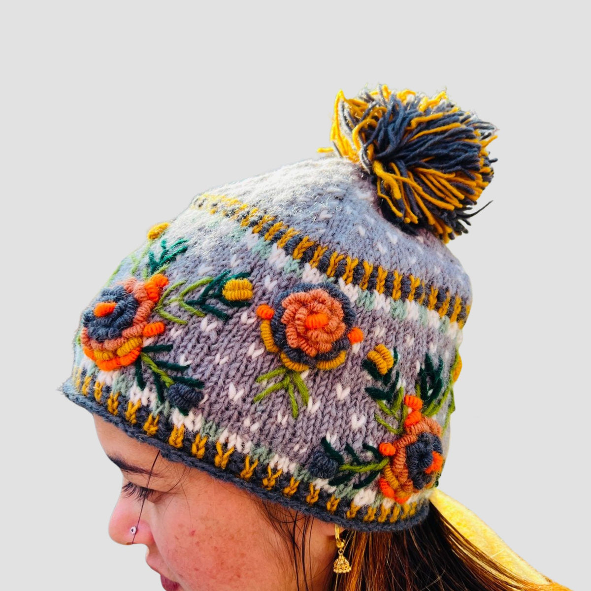 Woman wearing hand knitted floral winter beanie Nepal fair trade