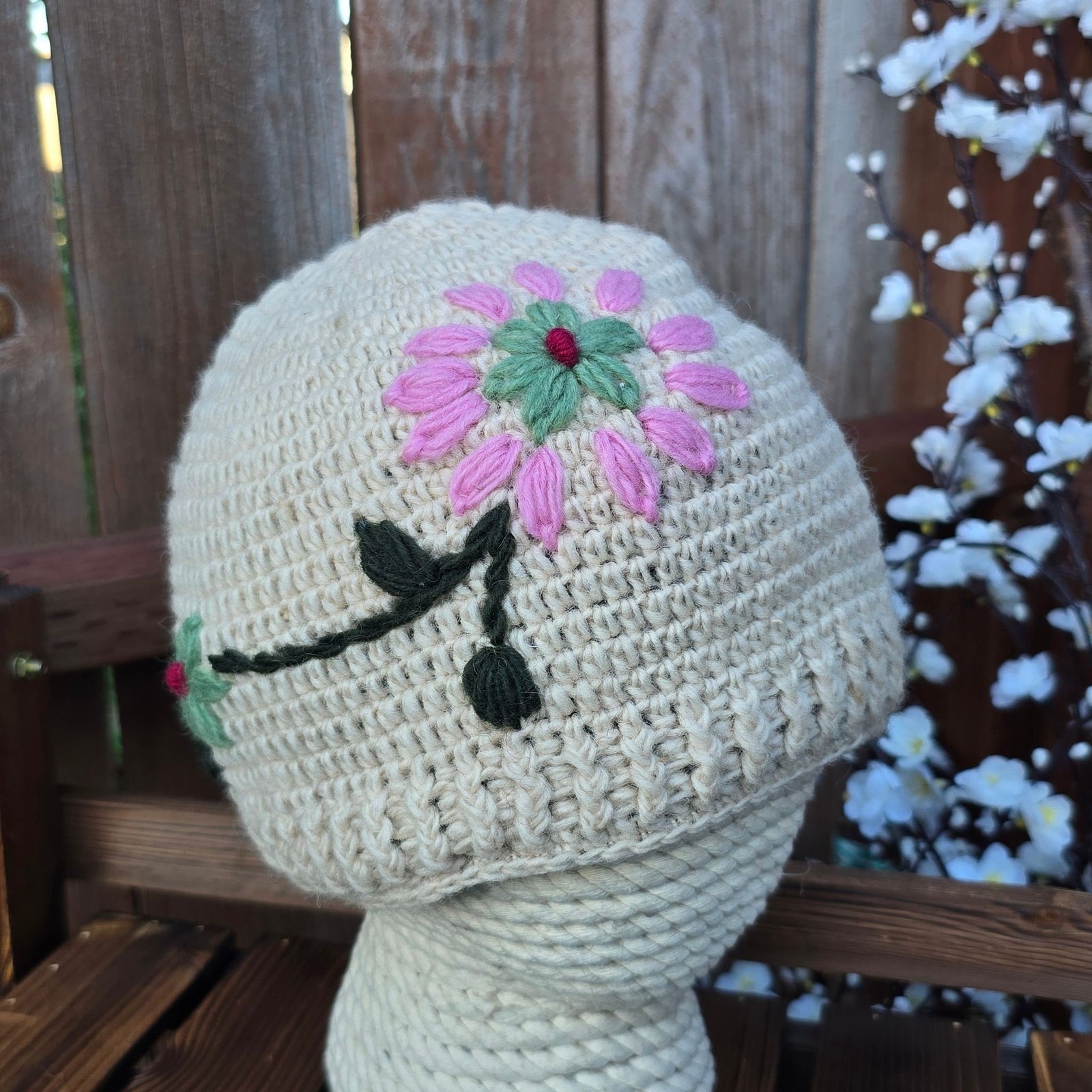 cream white hand knitted New Zealand wool beanie with pink sunflower and black stem botanical embroidery handmade in Nepal