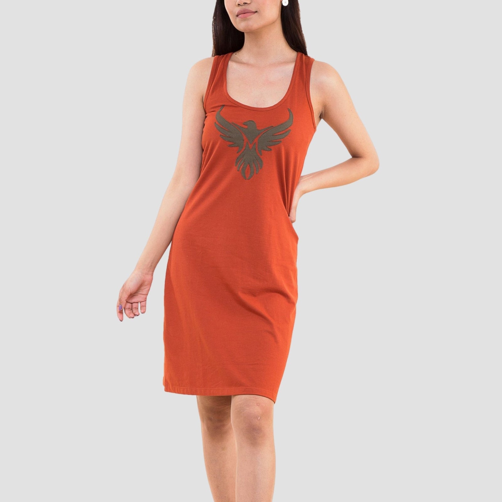 Woman wearing rust orange organic cotton tank dress with phoenix bird print on chest, knee-length sleeveless design